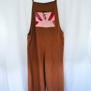 Clay colored linen wide leg overalls with pink sun collage patch as front pocket 