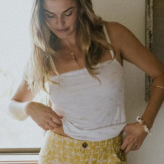 Model wearing Wings Hawaii retro pocket shorts in quilted ulu and plumeria print in marigold