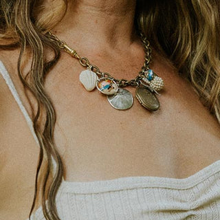 Model wearing Wings Hawaii brass chain charm necklace with sand dollar and shell charms and locket