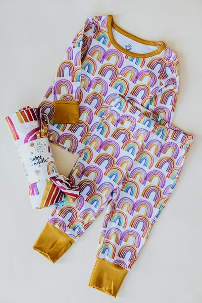 Wings Hawaii rainbow keiki pajamas shown with rainbow baby swaddle