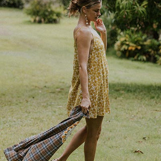 Wings Hawaii model wearing trapeze mini dress in ulu and plumeria print in marigold