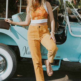 Model wearing Wings Hawaii retro pocket pants in marigold corduroy
