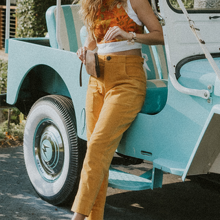 Model wearing Wings Hawaii retro pocket pants in marigold corduroy