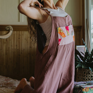 Linen rose colored wide leg overalls with collage sun patch as front pocket