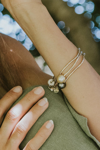 A gold hammered bracelet featuring a south seas pearl