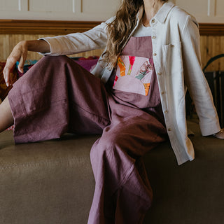 Linen rose colored wide leg overalls with collage sun patch as front pocket