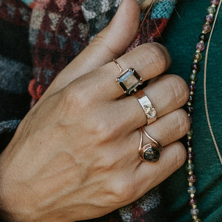 A raw diamond prong set on a 14K Yellow Gold Thick Band Ring
