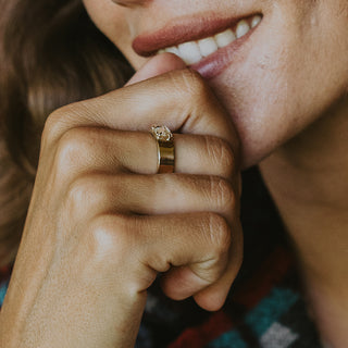 A raw diamond prong set on a 14K Yellow Gold Thick Band Ring