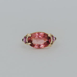 Piece of Tourmaline prong set in between two pink sapphires set in solid 14k yellow gold ring
