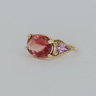 Piece of Tourmaline prong set in between two pink sapphires set in solid 14k yellow gold ring