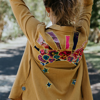 Marigold color button down blouse with sun moon collage on the back in vintage Hawaiian barkcloth