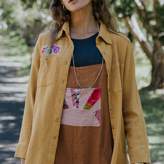 Marigold color button down blouse with sun moon collage on the back in vintage Hawaiian barkcloth