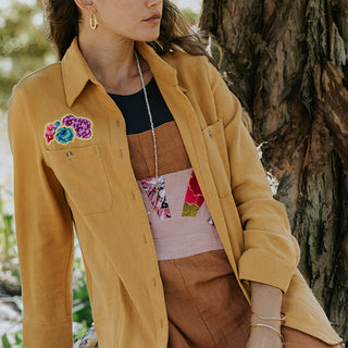 Marigold color button down blouse with sun moon collage on the back in vintage Hawaiian barkcloth