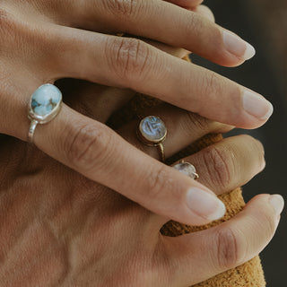 A moonstone carved in the shape of a sleeping moonfaced bezel set in a 14K yellow Gold ring