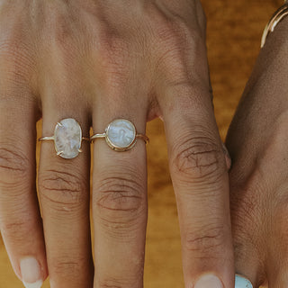 A moonstone carved in the shape of a sleeping moonfaced bezel set in a 14K yellow Gold ring