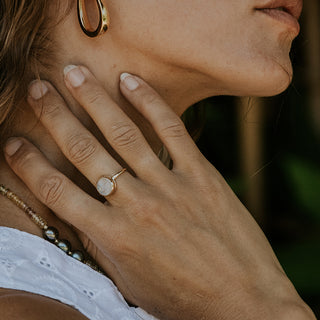 A moonstone carved in the shape of a sleeping moonfaced bezel set in a 14K yellow Gold ring