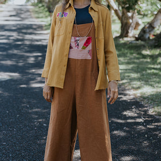 Clay colored linen wide leg overalls with pink sun collage patch as front pocket 