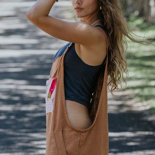 Clay colored linen wide leg overalls with pink sun collage patch as front pocket 