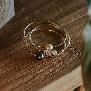 A hammered bangle with 5 Hawaiian puka shells