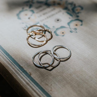 sterling silver and gold filled rings with a v shape sitting on a book